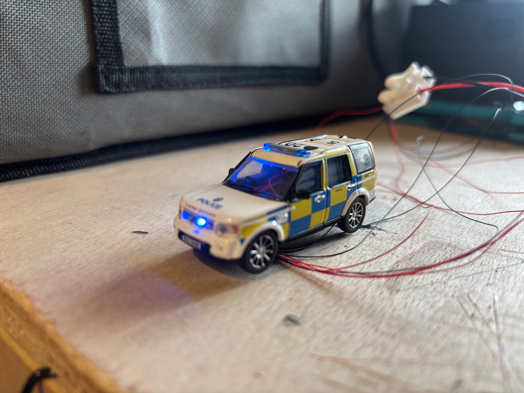 1:76 scale Oxford diecast Land rover police car with flashing lights