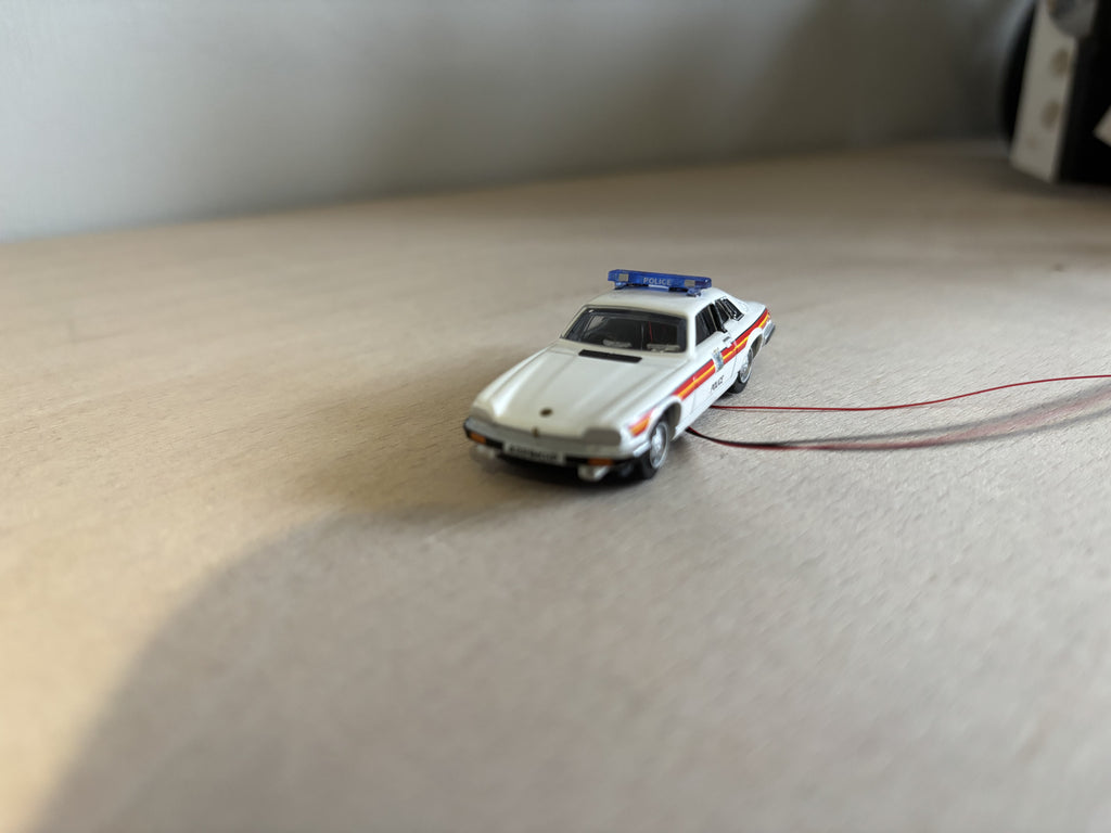 1:76 scale Oxford diecast Jaguar police car with flashing lights